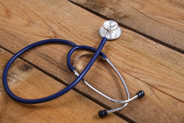 Closeup of a medical stethoscope, isolated on wooden background