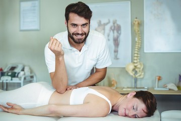 Obraz na płótnie Canvas Physiotherapist giving back massage to a woman