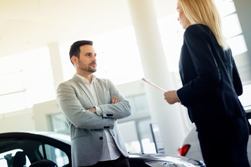 Salesperson selling cars at dealership