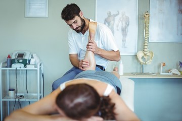 Physiotherapist giving leg massage to a woman © WavebreakMediaMicro