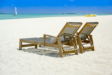 Fototapeta na wymiar Two beach chairs at ocean front