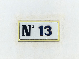 Street sign reading the number thirteen.