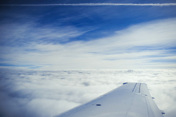 Fototapeta na wymiar an airplane wing above the clouds