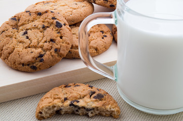 Glass cup with milk and oatmeal cookies with chocolate