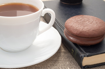 View close-up on white cup with cocoa and chocolate cake