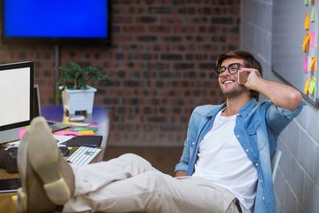 Fototapeta premium Smiling man talking on phone in office