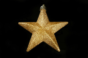 Gold glitter Christmas star on black