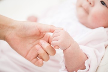 Fototapeta na wymiar 母親の指を握る赤ちゃん