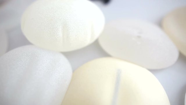 Close-up shot of breast implants on the table at beauty clinic office. Breast augmentation, enlargement, enhancement. Cosmetic surgery. Silicone breast implant. Plastic surgery.