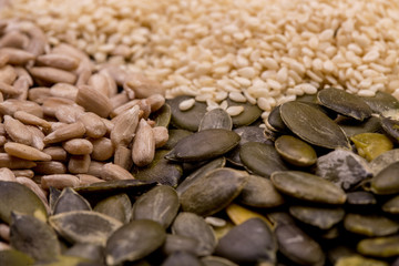 Sesame, pumpkin and sunflower seeds on wooden background