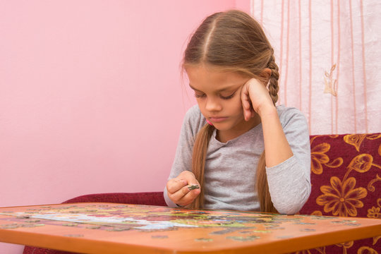 The girl does not know where to put the next puzzle element