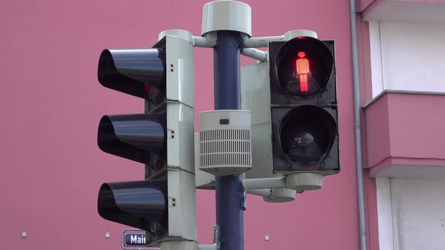 Crossing light for pedestrians goes from green to red.
