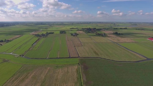 Aerial shot of green meadows and village in Holland.
