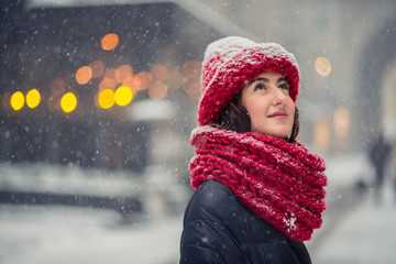 Girl standing in the street and it is snowing