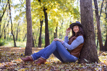 woman in hat sitting in the woods