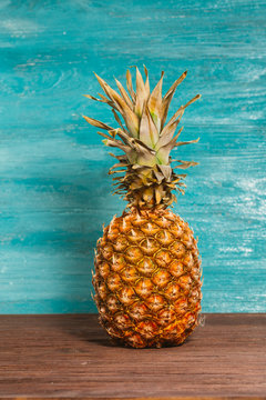 Pineapple is on the table a blue wooden background