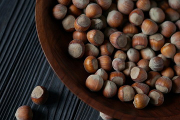hazelnuts in a wooden bowl on a dark background 