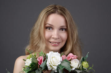 Beautiful smiling girl with a bouquet of flowers studio portrait