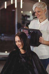 Hairdresser showing woman her haircut in mirror