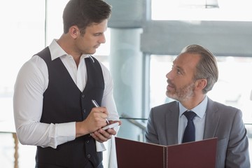 Waiter taking the order from a businessman