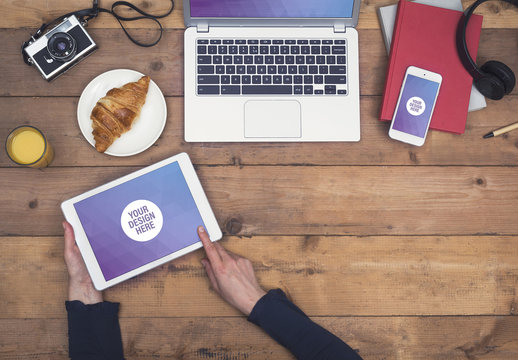 User with Tablet at Table with Food and Gadgets Mockup