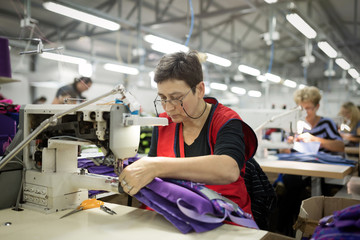 Woman working in textile industry - obrazy, fototapety, plakaty