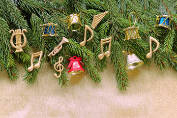 Musical notes, instruments on christmas tree brunch on golden background 