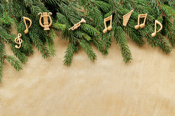 Musical notes, on christmas tree brunch on golden background 