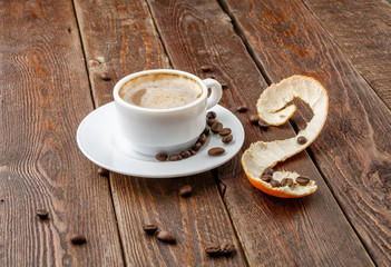 Coffee with tangerine peel on dark background