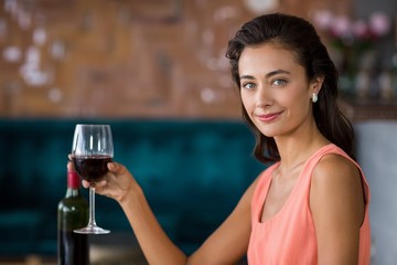 Smiling woman holding glass of red wine