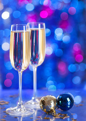 Two glasses of champagne with a Christmas decor in the background. very shallow depth of field, focus on near glass.