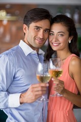 Portrait of young couple holding glass of wine