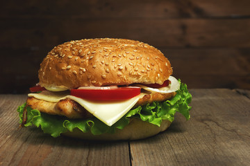 Home made hamburger on wooden background. Fastfood meal. Vintage toned