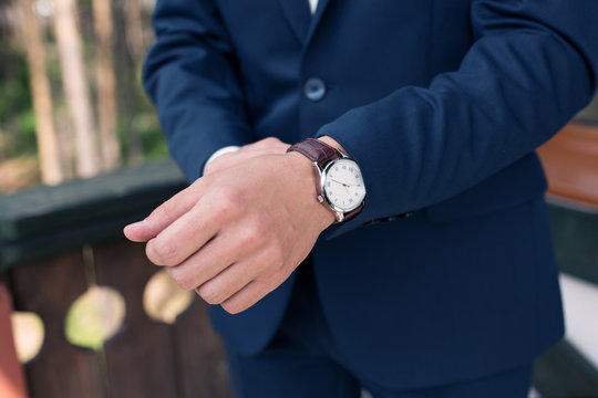 man in a stylish suit dresses a watch. Morning of the groom. Male clothes style