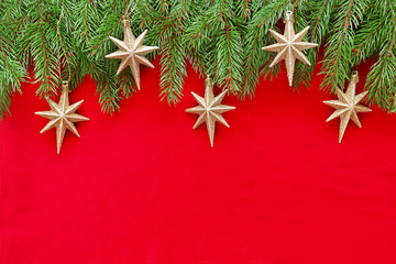 Golden stars on christmas tree branch on red velvet 