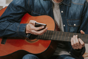hands with the mobile phone and the guitar