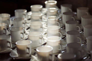 Obraz na płótnie Canvas Closeup image of white cups at blurred table background.