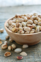 Wooden bowl with raw pistachios.