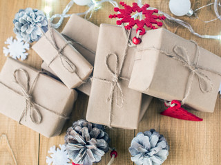 Kraft gift boxes, garland, Christmas decorations, cones on the wooden background. Shallow Selective focus.