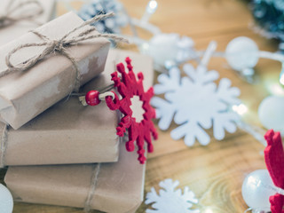 Kraft gift boxes, garland, Christmas decorations, cones on the wooden background. Shallow Selective focus.