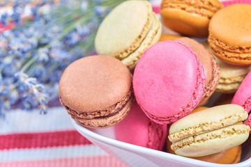 Colorful french macaroons in a white bowl