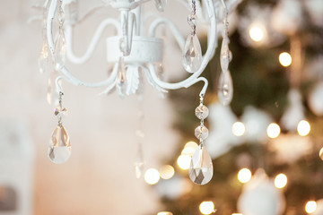 elegant chandelier in the background Christmas decorations, garlands, xmas tree. interior in white and gold colors