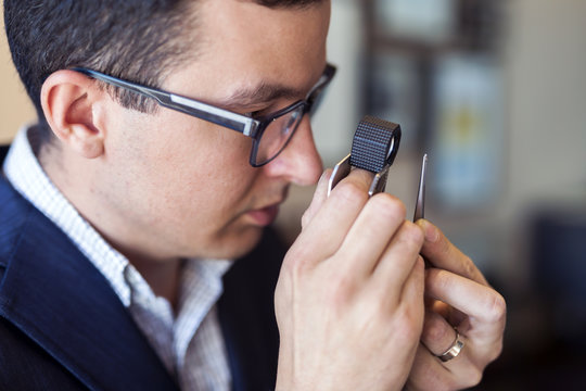 Jeweler examining diamond through loupe
