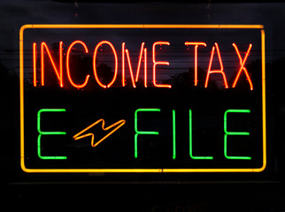 Neon income tax e file sign on black background. Horizontal.