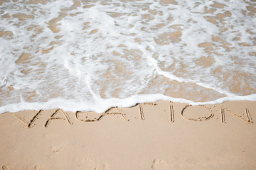 Vacation written on tropical beach white sand
