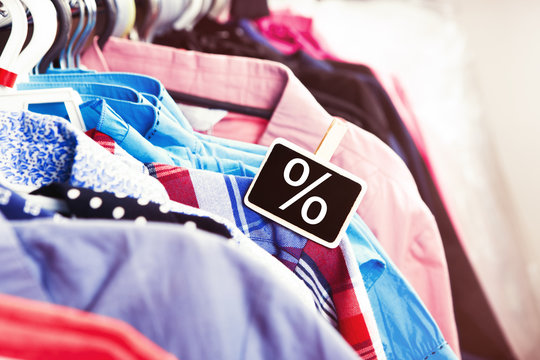 Colorful clothes hanging on a hanger and tag with discounts sign