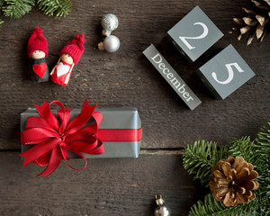 Christmas present with red ribbon, christmas calendar, pine branches, cone and xmas decorations. Christmas concept.