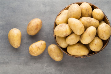 New potato on the bowl, gray background.