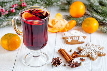 Christmas mulled wine with spices in cup on wooden background
