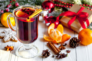 Christmas mulled wine with spices in cup on wooden background